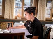 Eine Mitarbeiterin beim Reservierungsbuch im Hotel Ander